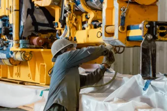 Employee prepping lift equipment for coatings